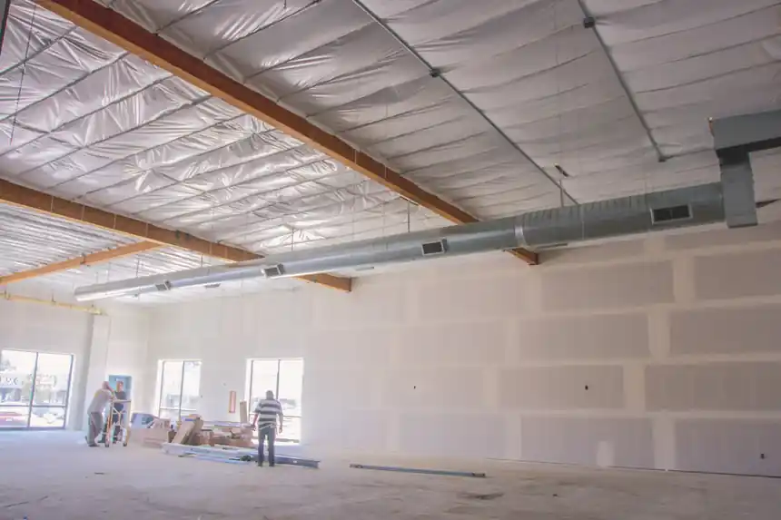 Long spiral duct run hung under the metal roof of an open commercial space