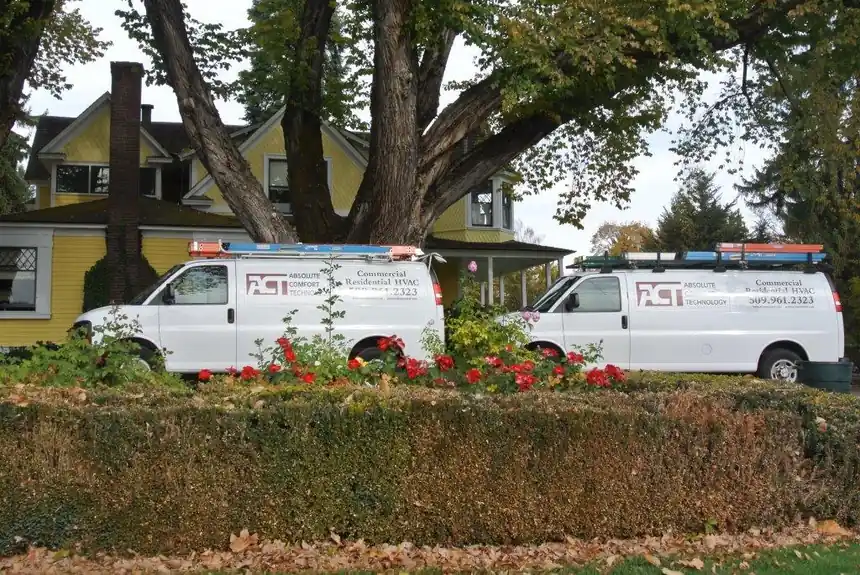 Two ACT vans outside a yellow Victorian house in autumn