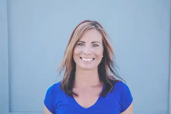 Lindsey Johnson, CFO of ACT Heat & Air, in front of a blue wall