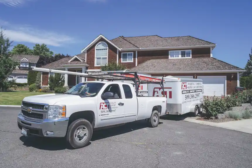 ACT pickup with ladder rack and trailer parked outside a two-storey Yakima home
