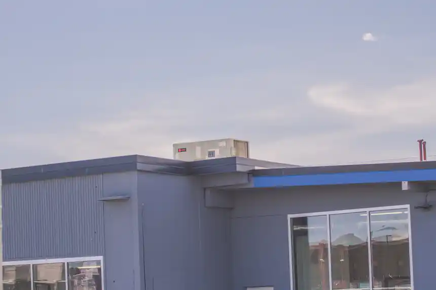 Rooftop units on a blue-sided building against the sky