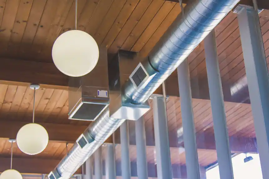 Exposed spiral duct under a wood ceiling in a finished retail space